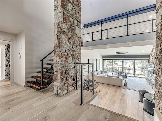 interior space featuring a towering ceiling and hardwood / wood-style floors