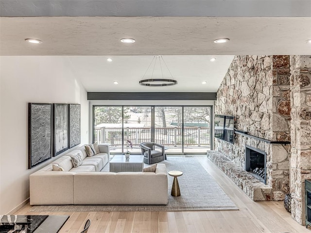 living room with baseboards, a healthy amount of sunlight, wood finished floors, and a fireplace