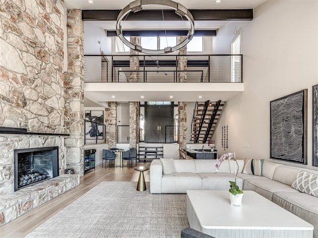 3108 Brush Creek Rd, Oklahoma City, OK 73120 - living room with wood finished floors, a high ceiling, a fireplace, beamed ceiling, and stairway