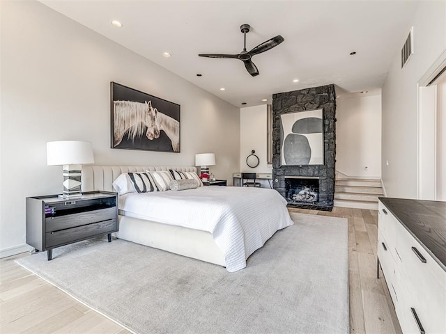 3108 Brush Creek Rd, Oklahoma City, OK 73120 - bedroom with light wood-type flooring, recessed lighting, a ceiling fan, and a fireplace