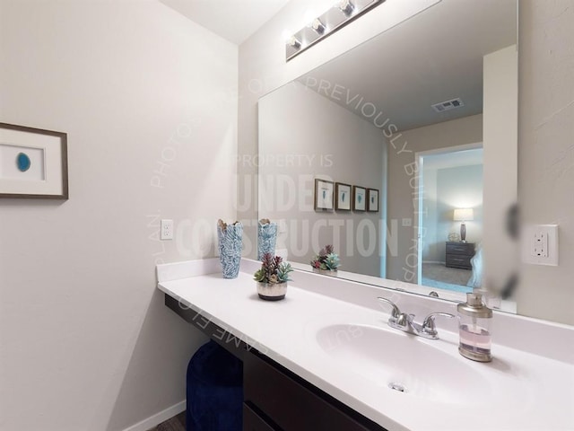 bathroom featuring visible vents, vanity, and baseboards