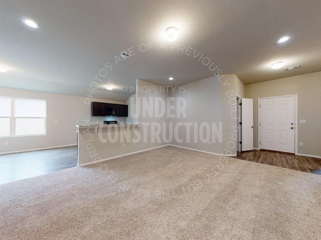 empty room with recessed lighting, visible vents, dark carpet, and baseboards