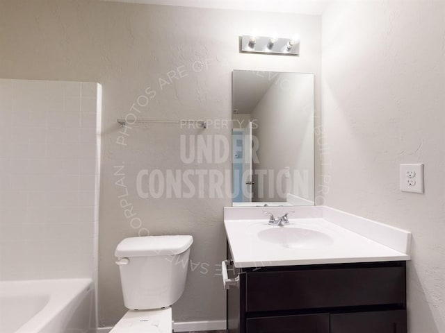 bathroom featuring a textured wall, vanity, and toilet