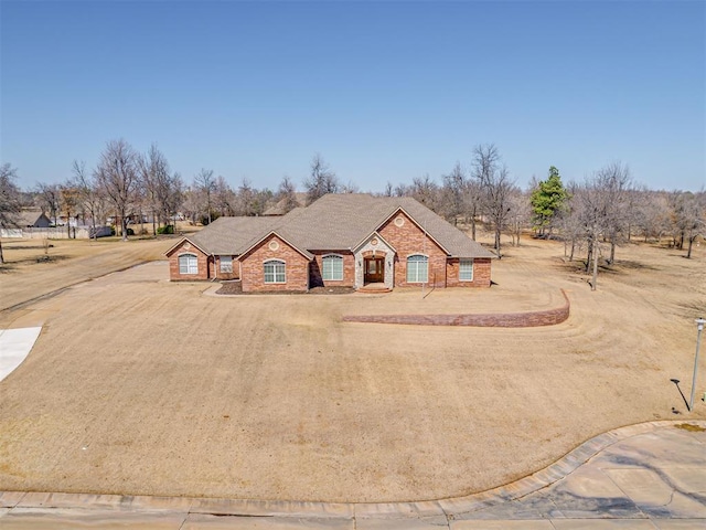 french country home featuring brick siding and driveway