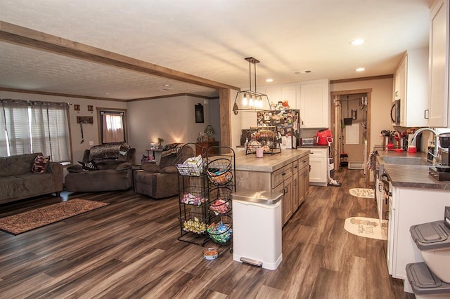 kitchen featuring open floor plan, ornamental molding, dark wood-style floors, and white cabinetry