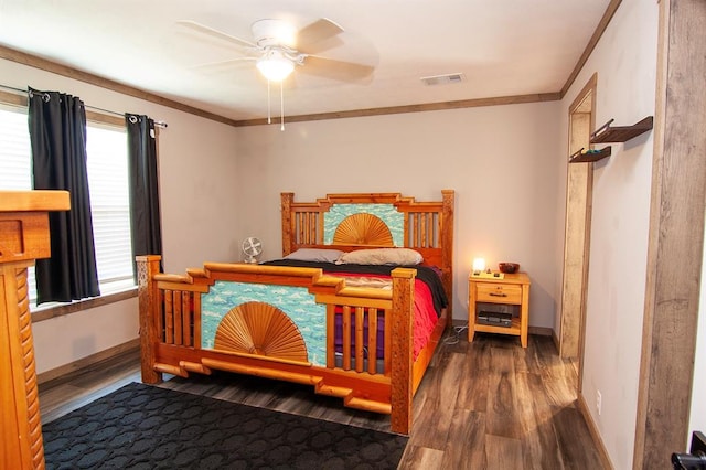 bedroom featuring ornamental molding, visible vents, baseboards, and wood finished floors