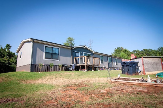 back of property featuring a deck and a yard