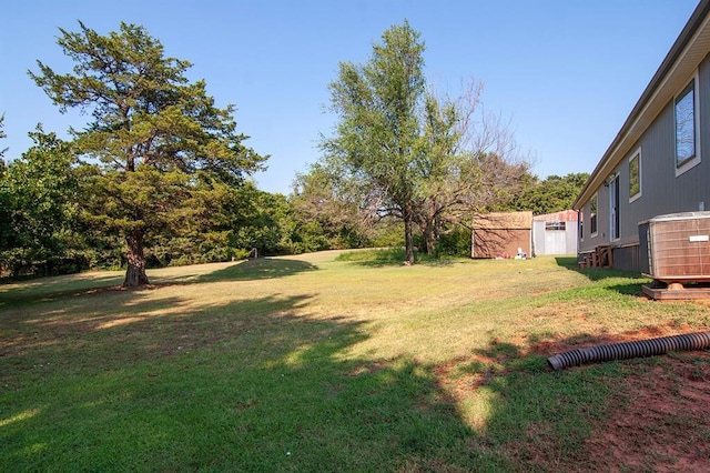 view of yard with a storage shed, central AC, and an outbuilding