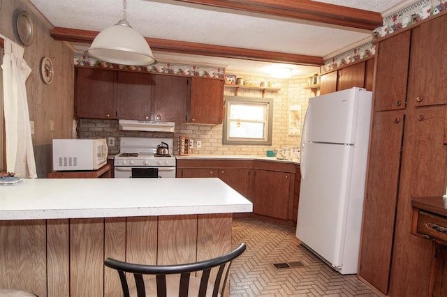 kitchen featuring a textured ceiling, under cabinet range hood, a peninsula, white appliances, and beamed ceiling