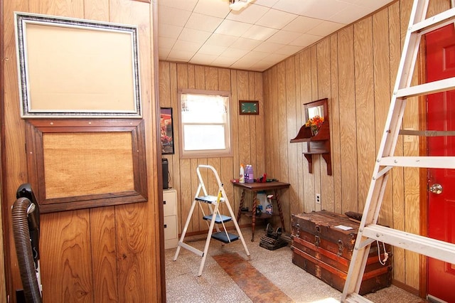 carpeted bedroom featuring wood walls