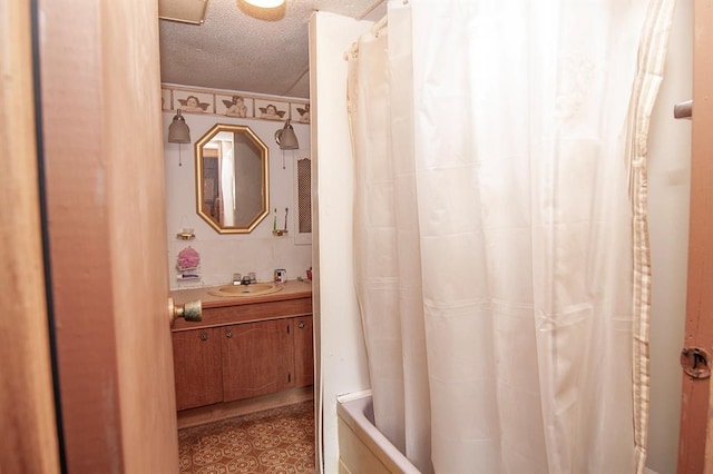 bathroom with a textured ceiling, shower / tub combo, vanity, and tile patterned floors