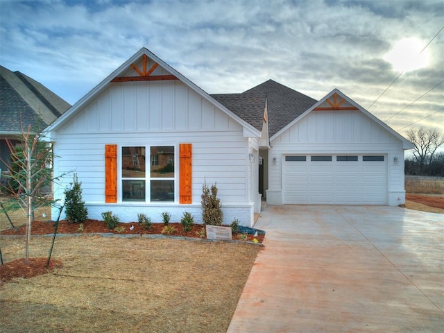 view of front of house featuring brick siding, a shingled roof, an attached garage, board and batten siding, and driveway