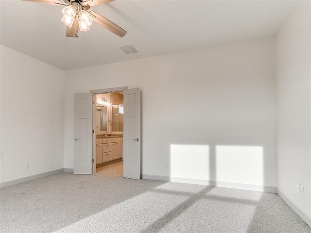 spare room featuring light carpet, baseboards, visible vents, and a ceiling fan