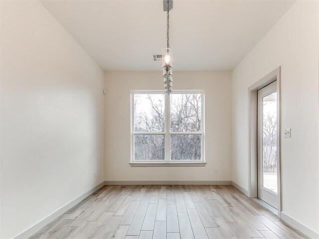 unfurnished dining area with light wood-style flooring and a wealth of natural light