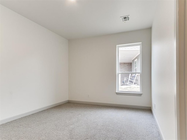 unfurnished room with light colored carpet, visible vents, and baseboards