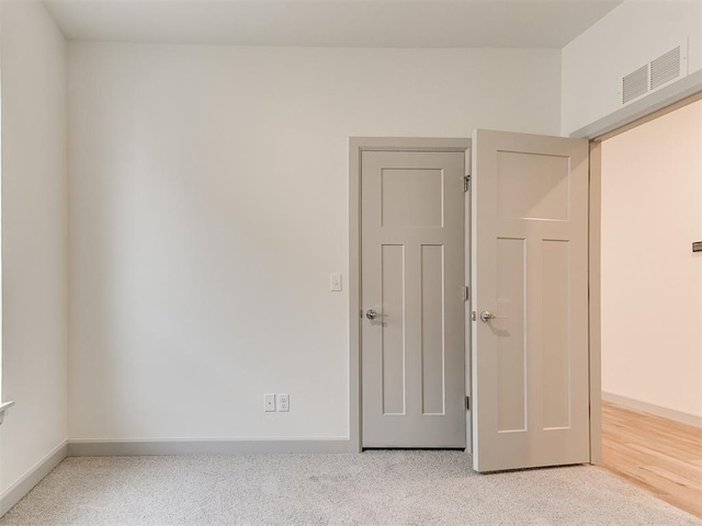 spare room with carpet, baseboards, and visible vents