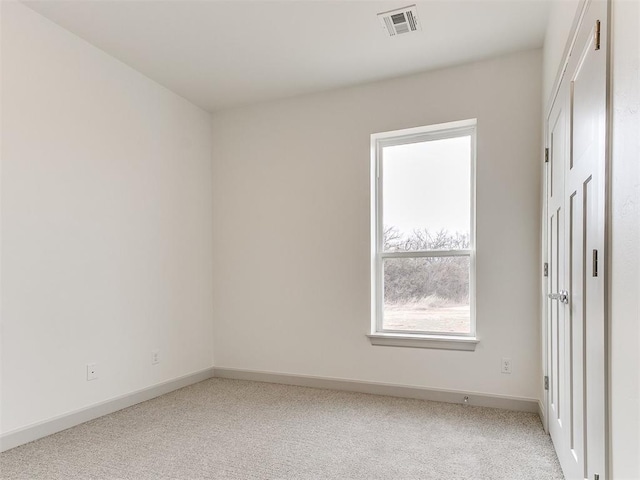 empty room with light carpet, baseboards, and visible vents