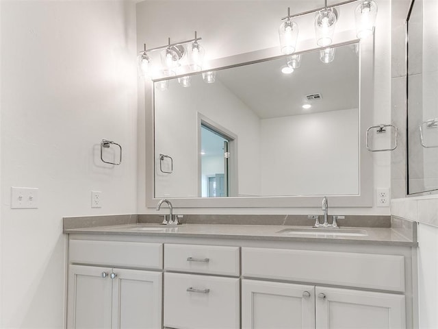 full bathroom featuring double vanity, visible vents, and a sink