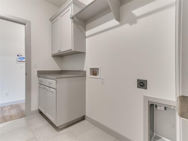 laundry area featuring baseboards, washer hookup, cabinet space, and hookup for an electric dryer