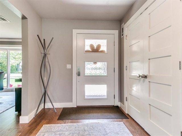 entrance foyer featuring baseboards, visible vents, and wood finished floors