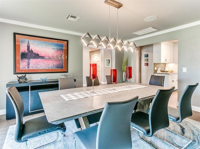 dining area featuring baseboards, visible vents, light wood-style flooring, and ornamental molding