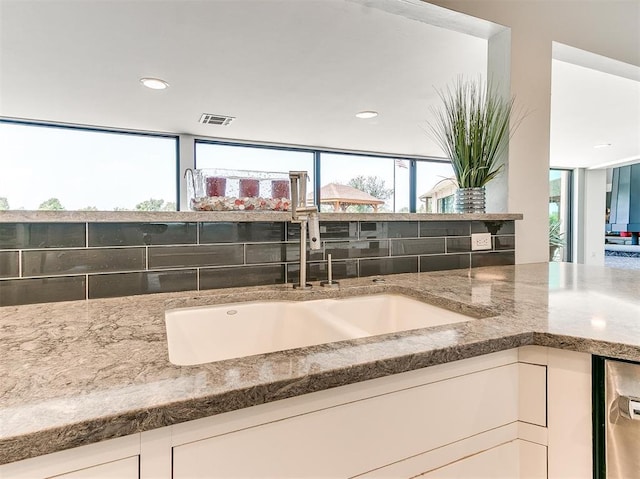 bathroom with a healthy amount of sunlight, visible vents, a sink, and recessed lighting