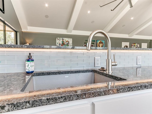 room details with a sink, backsplash, and beam ceiling