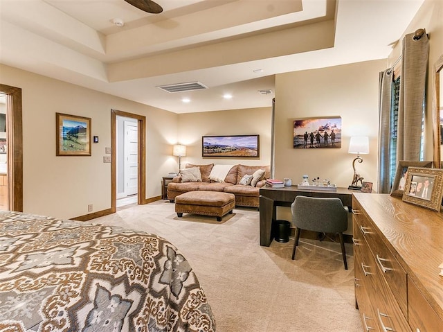 bedroom featuring light carpet, a raised ceiling, visible vents, and baseboards