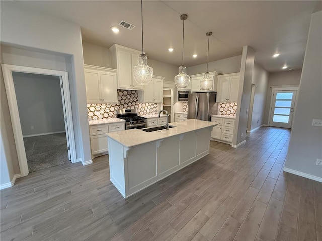 kitchen featuring appliances with stainless steel finishes, a sink, and white cabinets