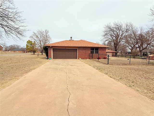 view of side of property featuring a garage, concrete driveway, brick siding, and fence