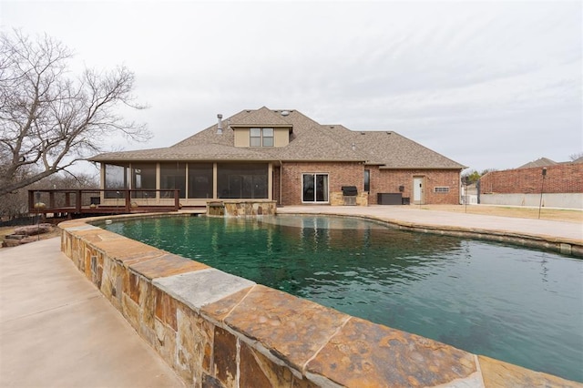 view of pool featuring a sunroom, a patio area, a deck, and a fenced in pool