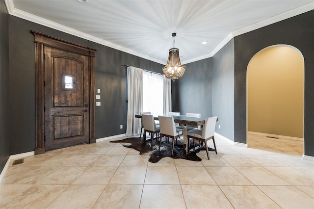 dining area featuring arched walkways, ornamental molding, light tile patterned floors, and baseboards