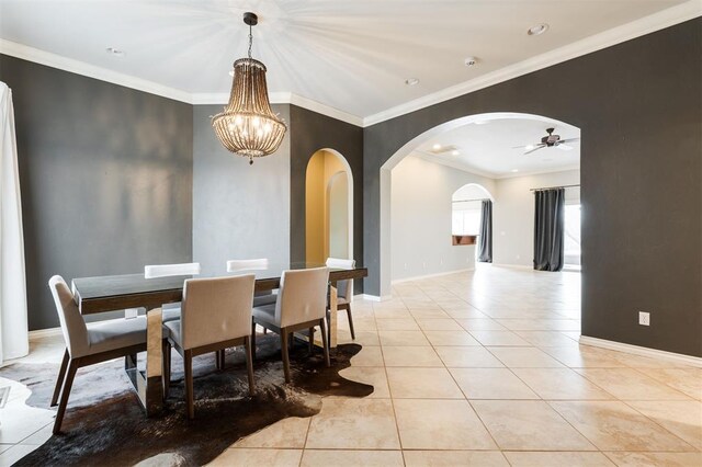 dining room featuring arched walkways, baseboards, ornamental molding, light tile patterned flooring, and ceiling fan with notable chandelier