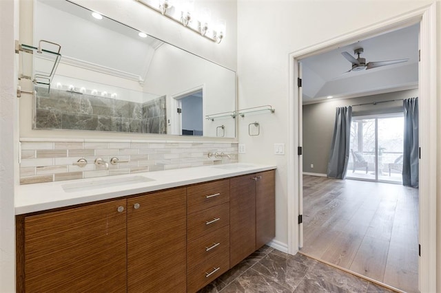 bathroom with double vanity, tasteful backsplash, ceiling fan, and a sink