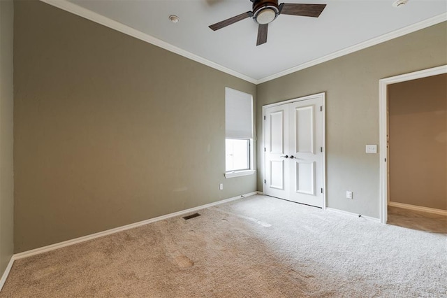 unfurnished bedroom with ornamental molding, carpet, visible vents, and baseboards