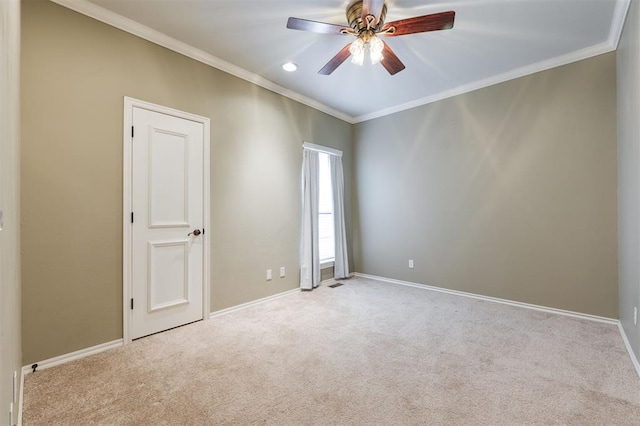 unfurnished room featuring a ceiling fan, carpet flooring, crown molding, and baseboards