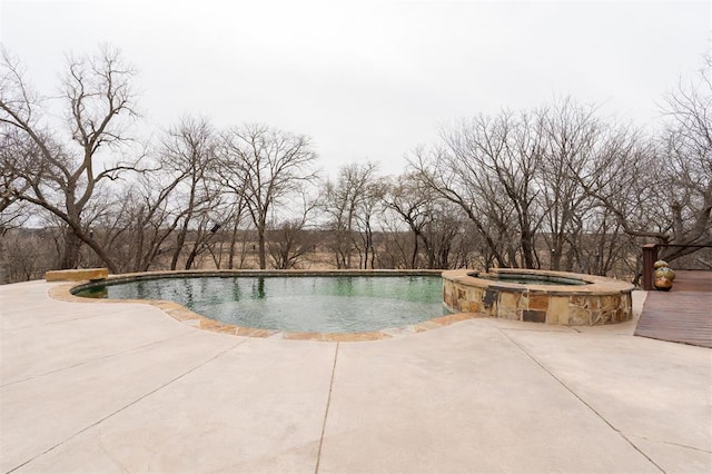 view of pool with a pool with connected hot tub and a patio area