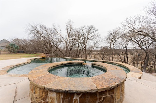 view of swimming pool with an in ground hot tub