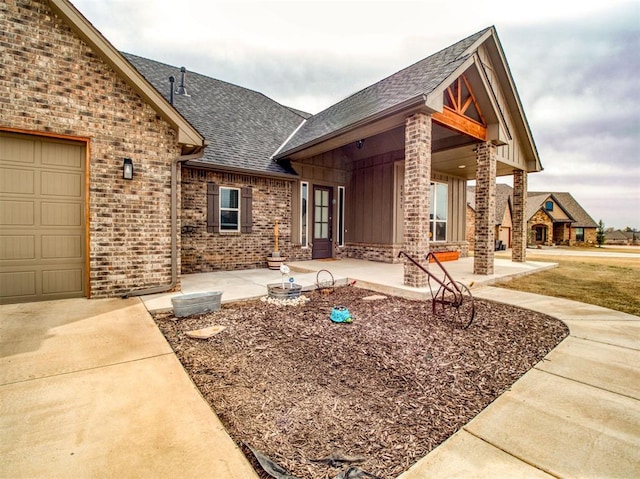 exterior space featuring board and batten siding, brick siding, and roof with shingles