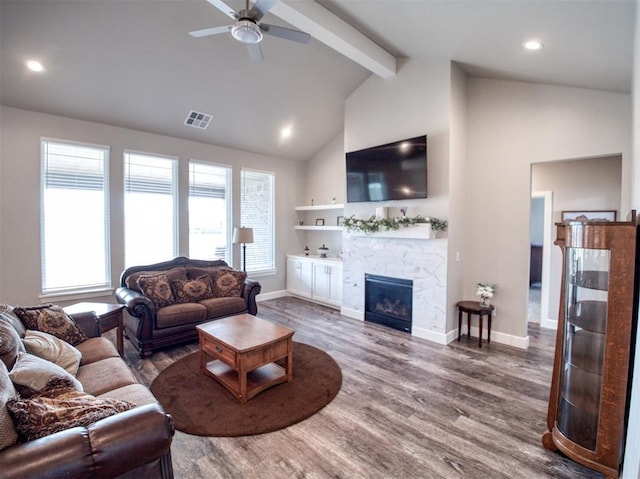 living area with visible vents, plenty of natural light, wood finished floors, and a fireplace