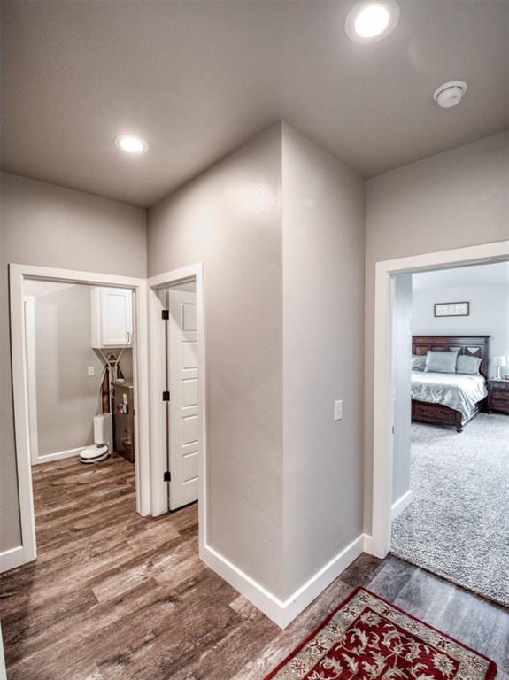 corridor with recessed lighting, baseboards, and dark wood finished floors