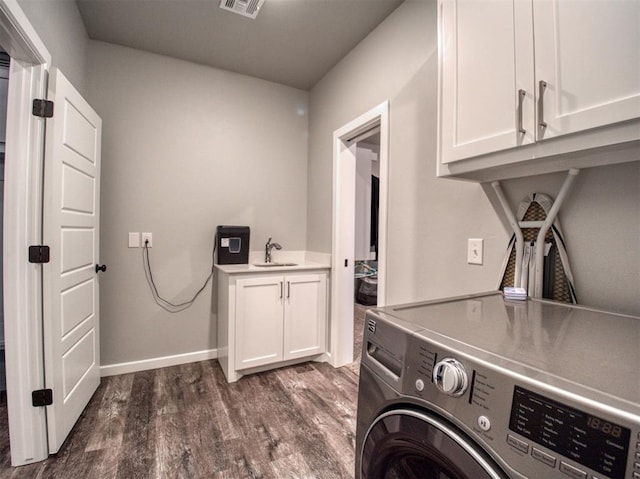 washroom featuring visible vents, washer / dryer, cabinet space, dark wood-style flooring, and a sink