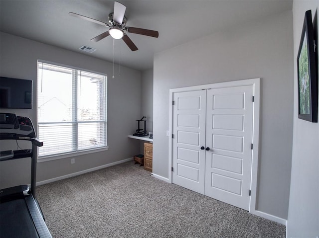 exercise room with visible vents, carpet floors, baseboards, and ceiling fan