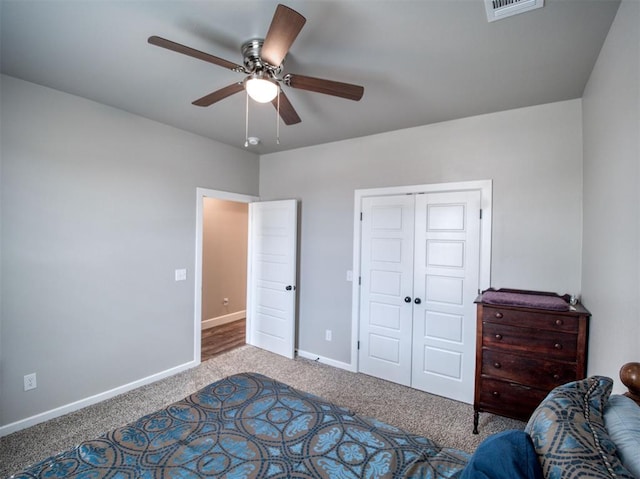 carpeted bedroom featuring baseboards, visible vents, a closet, and ceiling fan