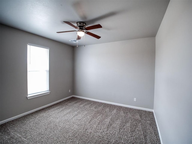 spare room with carpet, visible vents, baseboards, and ceiling fan