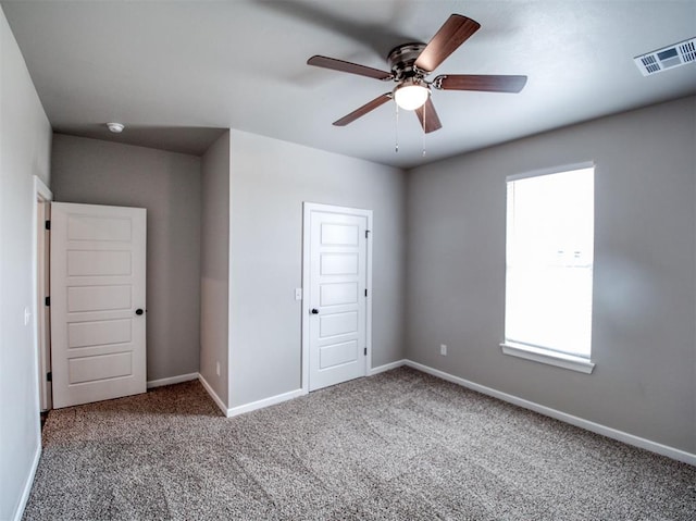 unfurnished bedroom with a ceiling fan, carpet flooring, visible vents, and baseboards