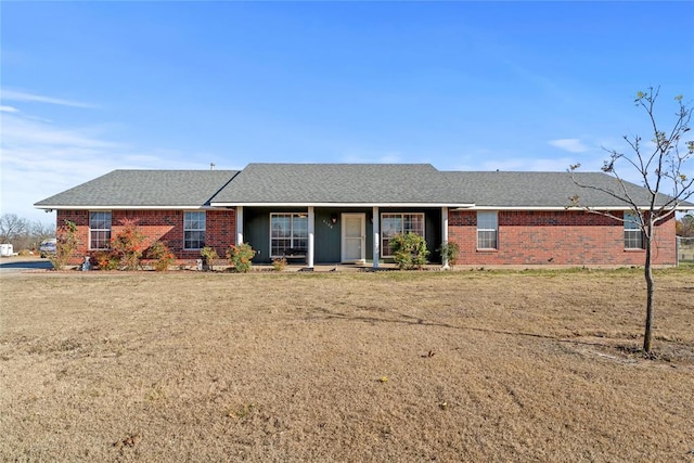 ranch-style house featuring brick siding and roof with shingles