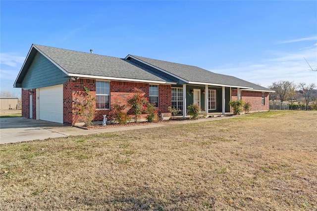 ranch-style house featuring an attached garage, brick siding, a shingled roof, driveway, and a front yard