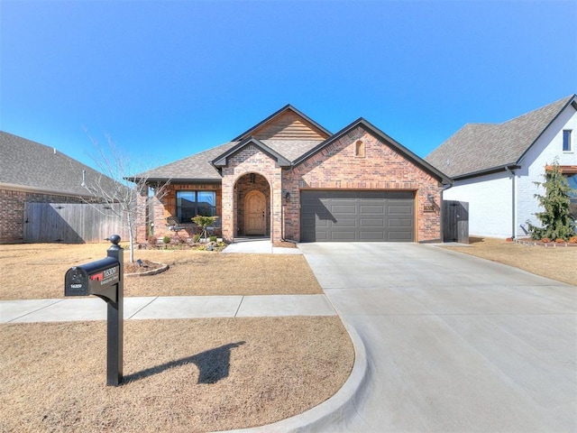 view of front of home with an attached garage, brick siding, a shingled roof, fence, and concrete driveway