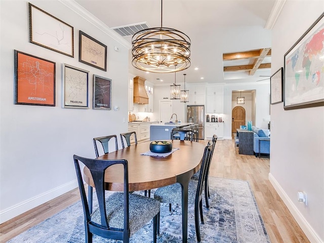 dining room with light wood finished floors, baseboards, visible vents, coffered ceiling, and a notable chandelier